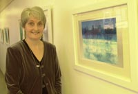 picture of artist Dorri Jones with one of her paintings at the Feeling4Life exhibition